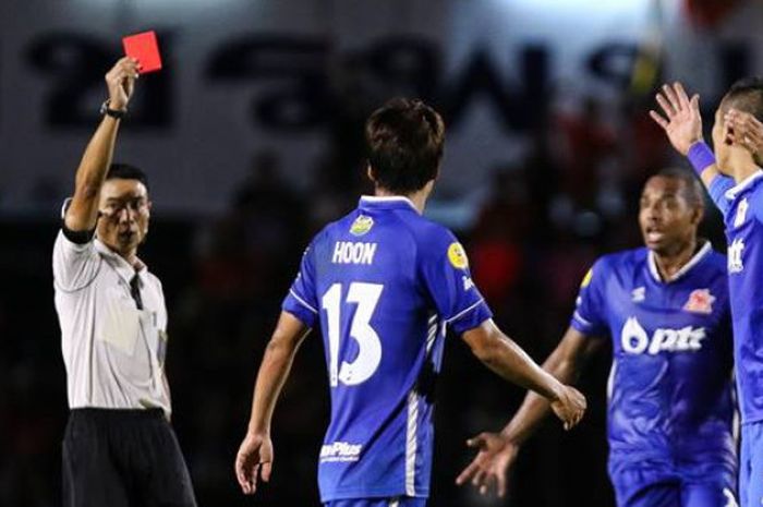 Wasit memberikan kartu merah ke bek PTT Rayong asal Indonesia, Ryuji Utomo (kanan) saat mereka dijamu Udon Thani FC pada lanjutan Liga Thailand 2 untuk pekan ke-17, 30 Juni 2018.