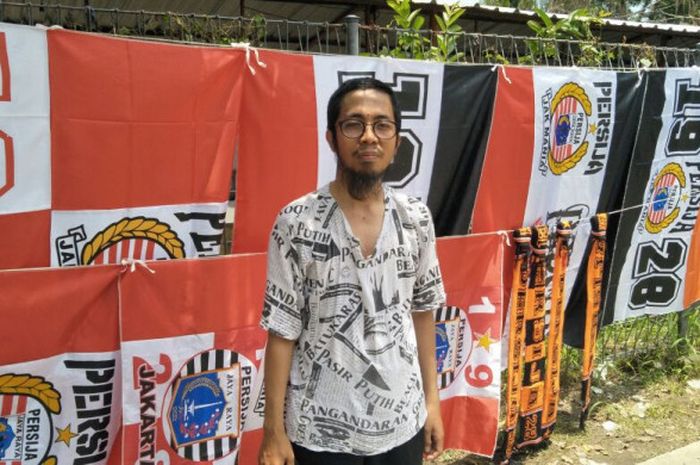 Ansaf, penjual pernak-pernik Persija Jakarta yang sedang berjualan di Stadion Manahan, jelang laga Persija kontra PSMS Medan pada Sabtu (10/2/2018).