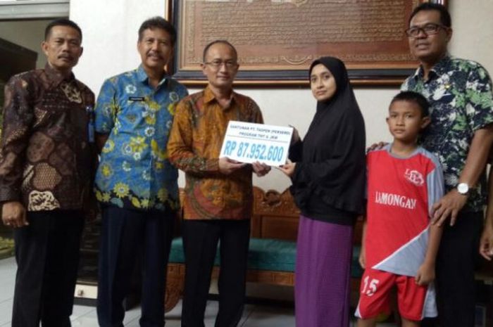Kepala PT Taspen Kantor Cabang Utama Surabaya, Achmad Muhtarom menyerahkan hak almarhum Choirul Huda sebagai ASN kepada istrinya, Lidya Anggraini, di rumahnya, Jumat (20/10/2017).