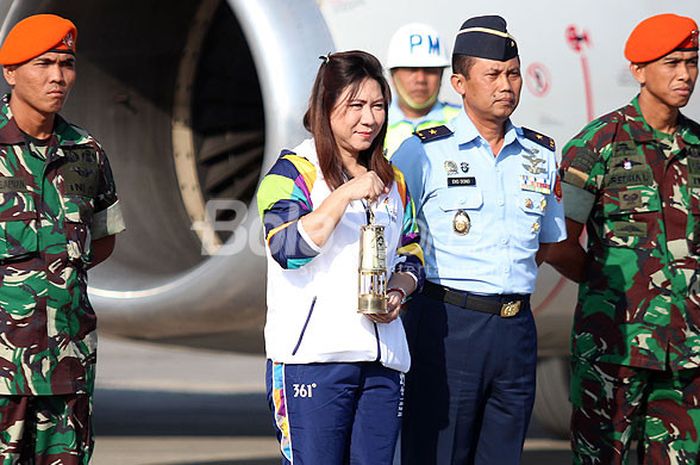   Mantan pebulu tangkis nasional Indonesia, Susy Susanti (tengah), yang membawa api dari India untuk kirab obor Asian Games 2018 saat tiba di Bandara Adi Sutjipto, Yogyakarta, Selasa (17/7/2018).  