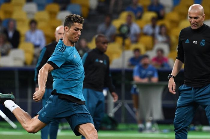 Pelatih Real Madrid, Zinedine Zidane (kanan), menyaksikan Cristiano Ronaldo menendang bola dalam sesi latihan di Stadion Olimpiyskiy, Kiev, Ukraina pada 25 Mei 2018.