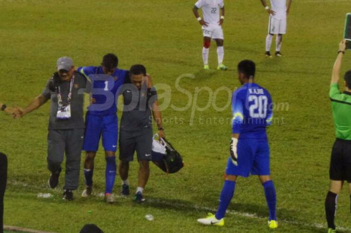 Satria Tama dipapah ke luar lapangan pertandingan setelah mengalami cedera pada pertandingan Indonesia vs Vietnam di Selayang, Selasa (22/8/2017). 