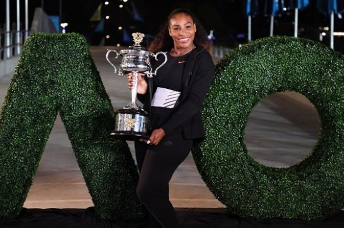 Petenis Amerika Serikat, Serena Williams, berpose dengan trofi juara Australia Terbuka 2017 seusai mengalahkan sang kakak, Venus Williams, 6-4, 6-4, pada laga yang berlangsung di Melbourne Park, Minggu (29/1/2017).