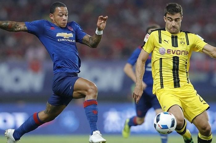 Penyerang Man United, Memphis Depay, berduel dengan bek Borussia Dortmund, Sokratis Papastathopoulos di laga International Champios Cup di Stadion Shanghai, Jumat (22/7/2016).