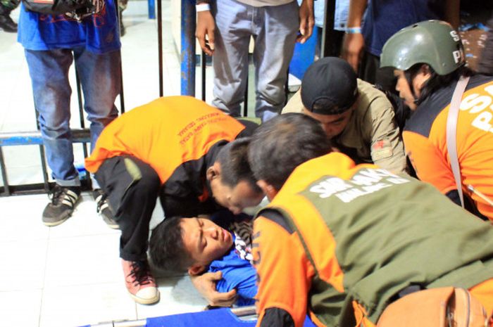 Para petugas medis menolong Aremania yang pingsan di Stadion Kanjuruhan seusai laga Arema FC vs Persib Bandung , Minggu (15/4/2018). 