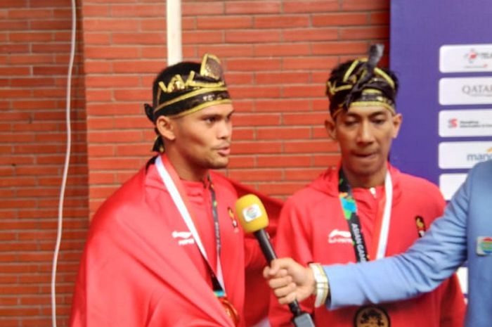Pasangan atlet pencak silat Indonesia peraih emas Asian Games 2018 dari nomor seni berpasangan putra, Yola Primadona Jampil dan Hendy.