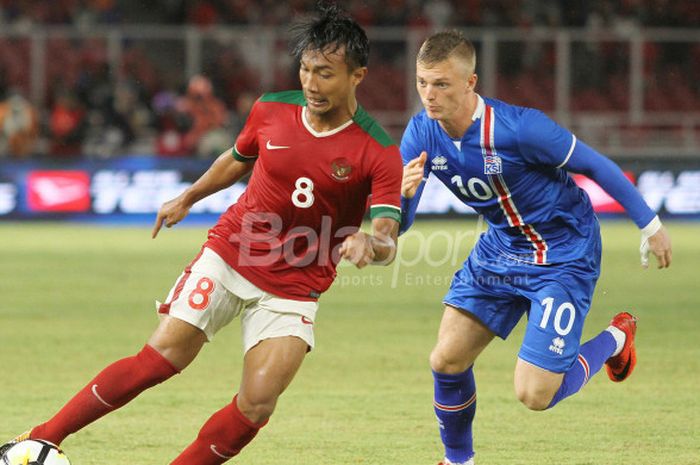 Gelandang timnas Indonesia, Muhammad Hargianto, membawa bola dibayang-bayangi penyerang Islandia, Albert Gudmundsson, pada laga uji coba internasional di Stadion Utama GBK, Jakarta Selatan, Minggu (14/1/2018) malam. 