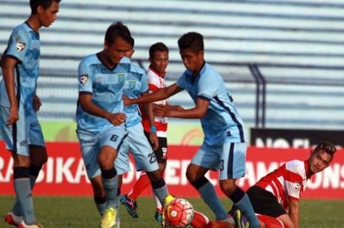Para pemain Persela U-21 (biru) berebut bola dengan pilar Madura United U-21 di Stadion Surajaya, Lamongan, Jumat (19/8/2016). 