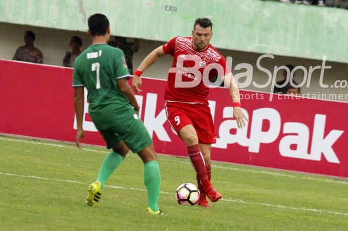 Pemain Persija, Marko Simic berusaha melewati pemain PSMS Medan, Roni Fatahilah di Stadion Manahan, Solo, Senin (12/2/2018)