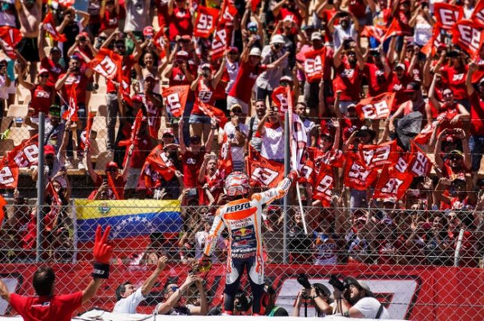 Marc Marquez merayakan keberhasilannya naik podium bersama para penggemarnya pada MotoGP Catalunya 2017.