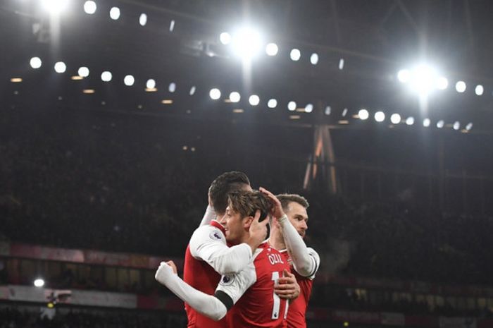 Striker Arsenal, Olivier Giroud (kiri), merayakan golnya bersama Mesut Oezil (tengah) dan Aaron Ramsey dalam laga Liga Inggris kontra Huddersfield Town di Stadion Emirates, London, pada 29 November 2017.