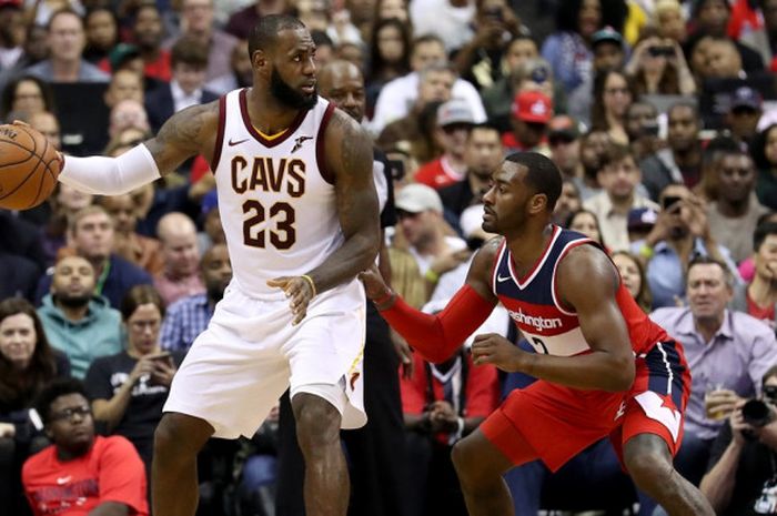 Pebasket Cleveland Cavaliers, LeBron James (jersey putih, #23). mendribel bola seraya dijaga pemain Washington Wizards, John Wall, pada laga musim reguler NBA yang berlangsung di Capital One Arena, Washington, DC, Jumat (3/11/2017) malam waktu setempat.