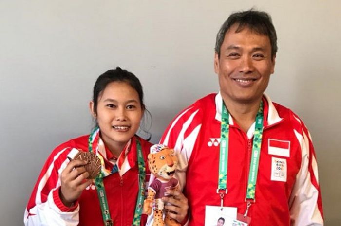Lifter remaja Indonesia, Putri Nur Vinatasari, berpose dengan medali perunggu yang didapat pada Olimpiade Remaja 2018.