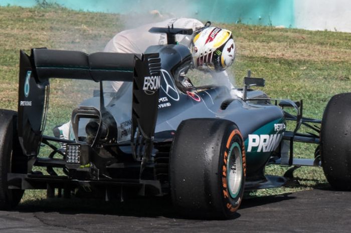 Pebalap Mercedes AMG Petronas F1, Lewis Hamilton, mengecek mobilnya setelah mengalami kerusakan mesin yang menyebabkan dia gagal finis pada GP Malaysia 2016.