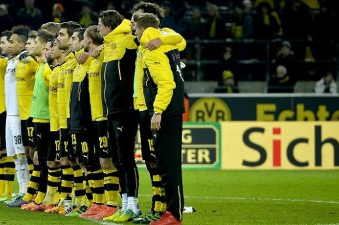 Para pemain Borussia Dortmund berdiri sejajar untuk menghormati salah satu suporter yang meninggal dunia akibat serangan jantung, saat laga Bundesliga kontra Mainz 05 di Stadion Signal Iduna Park, Minggu (13/3/2016).