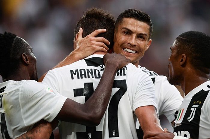Megabintang Juventus, Cristiano Ronaldo (kedua dari kanan), memeluk Mario Mandzukic yang mencetak gol ke gawang Lazio dalam laga Liga Italia di Allianz Stadium, Turin pada 25 Agustus 2018.