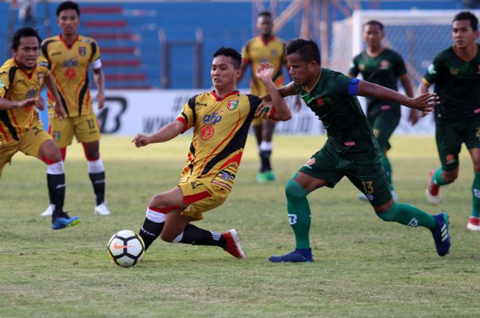 Gelandang Mitra Kukar, Anindito Wahyu Erminarno berusaha meindungi bola dari sergapan bek PS Tira, Manahati Lestusen pada laga pekan ke-15 Liga 1 2018 di Stadion Sultan Agung, Kabupaten Bantul, 10 Juli 2018. 
