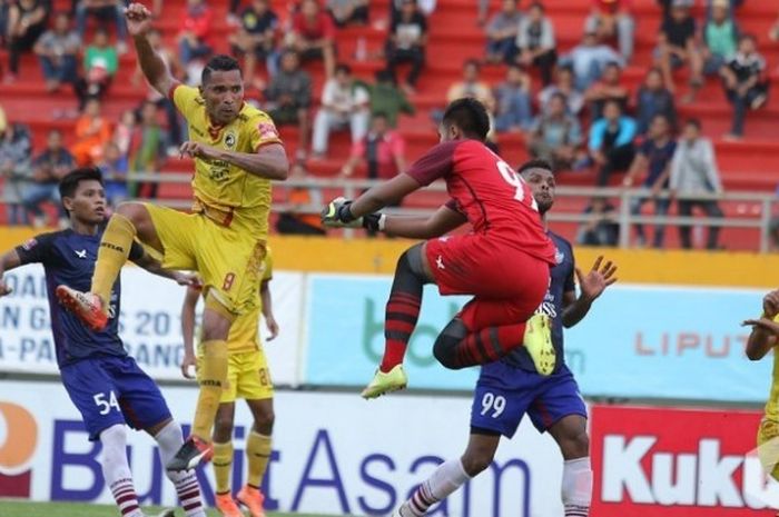 Kiper Persegres, Dimas Galih Pratama (kaus merah) terbang untuk coba menepis sundulan dari striker Sriwijaya FC, Alberto Goncalves di Stadion Jakabaring, Palembang, Kamis (13/10/2016).
