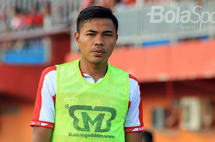 Gelandang Madura United, Asep Berlian, melakukan pemanasan saat Madura United menjamu Arema FC pada 