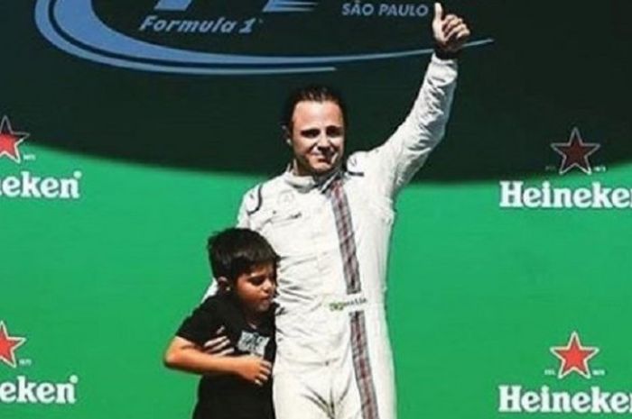 Pebalap Felipe Massa menaiki podium Sirkuit Jose Carlos Pace, Sao Paulo, Brasil, bersama putranya, Felipinho, selepas tampil di balapan F1 di sirkuit tersebut (12/11/2017).