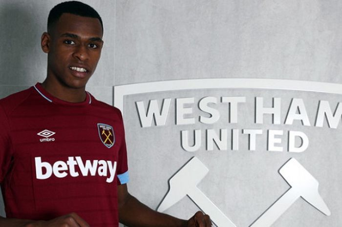 Bek baru West Ham United, Issa Diop, berpose bersama seragam dan logo tim setelah resmi menjadi pemain baru.