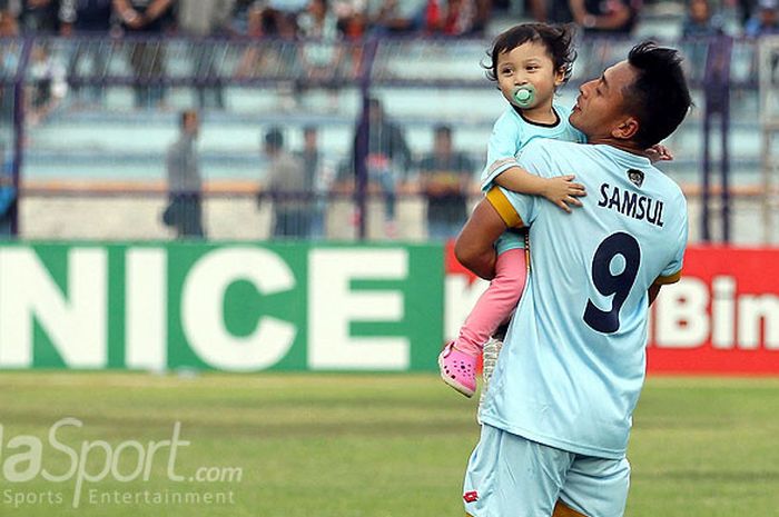 Penyerang Persela Lamongan, Samsul Arif, menggendong putrinya usai laga melawan PS TNI dalam laga pekan ke-26 Liga 1 di Stadion Surajaya Lamongan, Jawa Timur, Kamis (22/09/2017) sore.