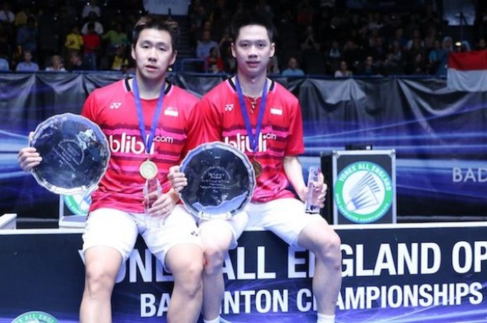 Pasangan ganda putra Indonesia, Marcus Fernaldi Gideon (kiri)/Kevin Sanjaya Sukamujo, berpose dengan trofi yang mereka dapatkan setelah mengalahkan pasangan China, Li Junhui/Li Yuchen, pada babak final All England di Barclaycard Arena, Birmingham, Minggu (12/3/2017).