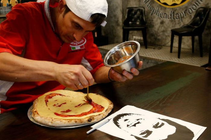 Valery Maksimchik, seorang koki di St.Petersburg sedang membuat pizza dengan tampilan wajah Luis Suarez.