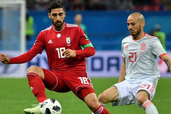 Aksi penyerang timnas Iran, Alireza Jahanbakhsh (kiri), saat menguasai bola dari penjagaan gelandang Spanyol, David Silva, dalam pertandingan Grup B Piala Dunia 2018 di Stadion Kazan Arena, Kazan, Rusia, pada 20 Juni 2018.