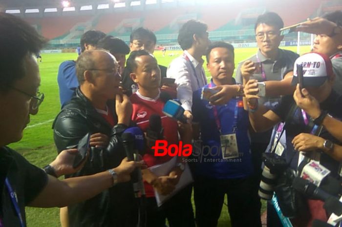 Pelatih timnas U-23 Vietnam, Park Hang-seo (dua dari kiri) dikerubuti wartawan jelang memimpin anak asuhnya latihan di Stadion Pakansari, Cibinong, Kabupaten Bogor pada Selasa (28/8/2018) petang.