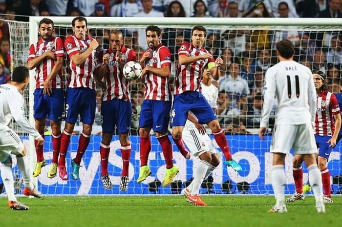 Momen Cristiano Ronaldo (kiri) mengeksekusi tendangan bebas dalam partai final Liga Champions antara Real Madrid versus Atletico Madrid di Stadion Da Luz, Lisabon, 24 Mei 2014.