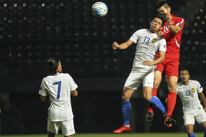 Duel udara antara penyerang timnas Malaysia, Syafiq Ahmad (13) dengan gelandang timnas Korut,Ri Yong