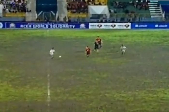 Lapangan Stadion Harapan Bangsa, Banda Aceh, berubah menjadi kubangan berlumpur saat Timnas Indonesia melayani Mongolia dalam Aceh World Solidarity Tsunami Cup 2018, Senin (4/12/2017) malam WIB. 
