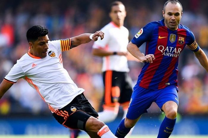 Pemain Valencia, Enzo Perez (kiri), melakukan tackle terhadap gelandang Barcelona, Andres Iniesta, dalam laga La Liga di Stadion Mestalla, 22 Oktober 2016.