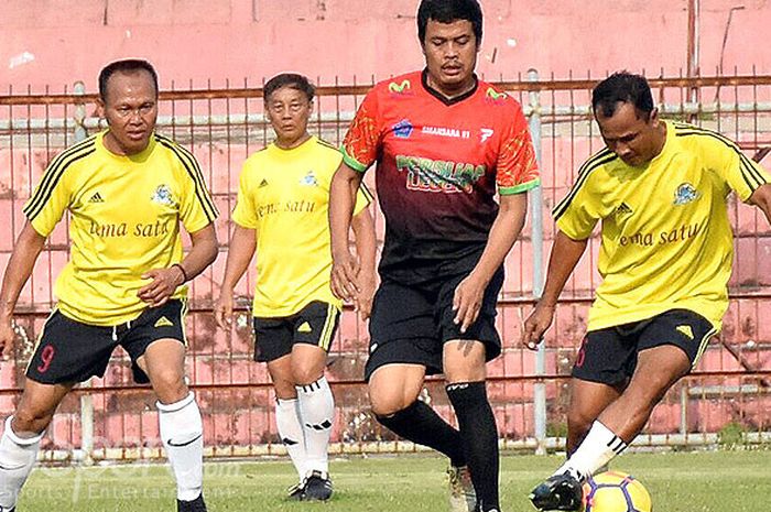 Pemain Mitra Devata, Ida Bagus Mahayasa (kuning/kanan) berusaha mengamankan bola dari hadangan pemain Persijap All Star (jersey orange-hitam) pada pertandingan trofeo antar legenda di Stadion Bumi Kartini, Jepara, Sabtu (28/4/2018)