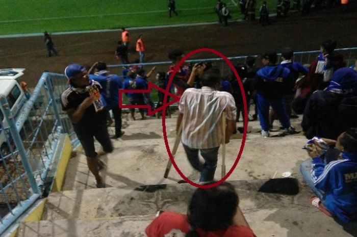 Aremania yang datang ke Stadion Kanjuruhan Malang dengan tongkat bantu (lingkaran merah) untuk menyaksikan aksi Arema FC.