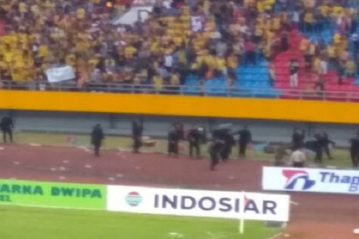 Penonton melempar kursi ke dalam stadion di laga Sriwijaya FC Vs Arema FC pada Sabtu (21/7/2018).