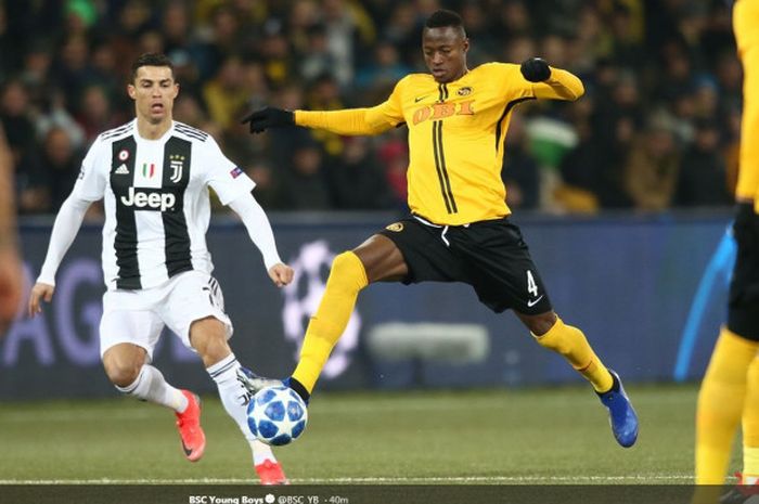 Megabintang Juventus, Cristiano Ronaldo (kiri), berduel dengan bek Young Boys, Mohamed Aly Camara, dalam laga Grup H Liga Champions di  Stade de Suisse, Bern, Swiss pada 12 Desember 2018.