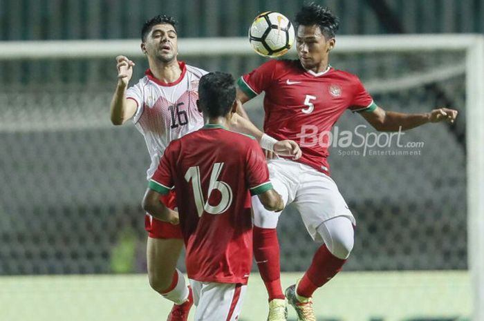  Bek Timnas U-23 Indonesia, Bagas Adi Nugroho, berduel udara dengan penyerang timnas U-23 Bahrain, Hashim Hashim, pada laga PSSI Anniversary Cup 2018 di Stadion Pakansari, Bogor, Jumat (27/4/2018) 