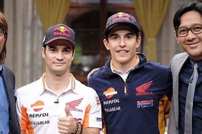 Pebalap tim Repsol Honda, Dani Pedrosa dan Marc Marquez, berpose bersama dua pembawa acara 