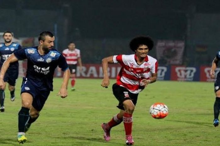  Gelandang Madura United, Ahmad Maulana Putra mencoba menjauhkan bola dari kejaran bek Arema, Goran Gancev di Stadion Gelora Bangkalan, Jumat (6/5/2016) malam.  