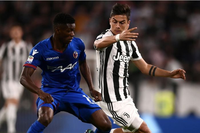  Penyerang Juventus, Paulo Dybala, tengah berebut bola dengan pemain Bologna, Ibrahima Mbaye, pada laga lanjutan Liga Italia di Allianz Stadium, Sabtu (5/5/2018) waktu setempat. 