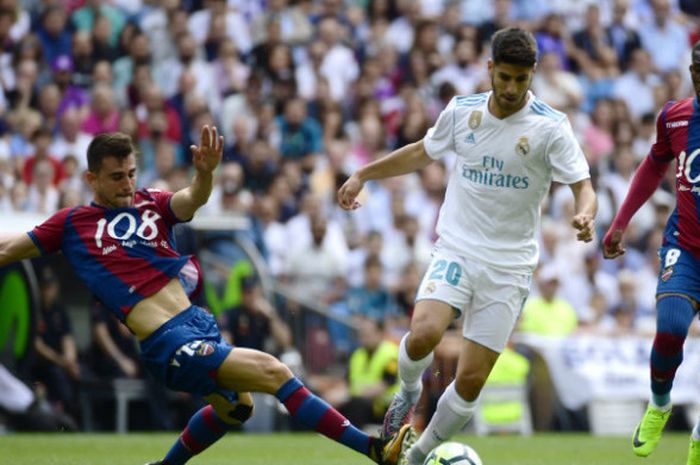 Pemain Real Madrid, Marco Asensio, melewati hadangan pemain Levante dalam lga di Santiago Bernabeu pada Sabtu (9/9/2017)