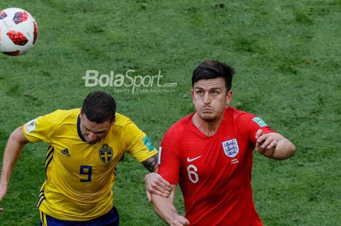 Bek Inggris, Harry Maguire (kanan), memperebutkan bola dengan penyerang Swedia, Marcus Berg, dalam partai perempat final Piala Dunia 2018 di Samara Arena, 7 Juli 2018.