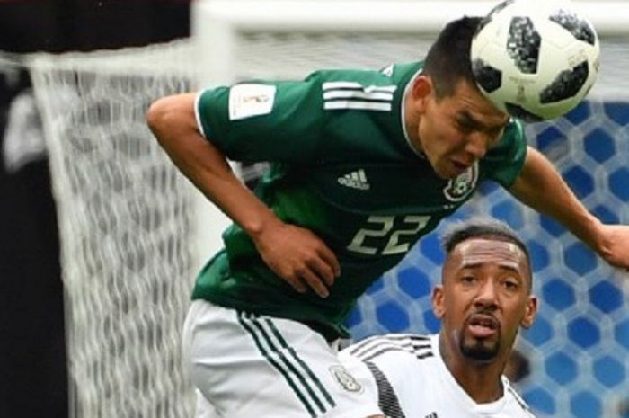   Hirving Lozano menyundul bola saat dibayang-bayangi Jerome Boateng pada laga Jerman vs Meksiko di Stadion Luzhniki, 17 Juni 2018.   