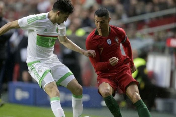 Penyerang tim nasional Portugal, Cristiano Ronaldo (kanan), saat mencoba melewati kawalan pemain Aljazair, Zidane Ferhat, pada laga uji coba di Estadio Da Luz, Lisabon, Portugal, pada Rabu (7/6/2018). 