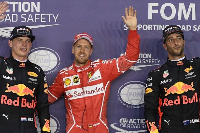 Pebalap Red Bull Racing, Daniel Ricciardo (kanan), berfoto dengan rekan satu timnya, Max Verstappen (kiri), dan pebalap Scuderia Ferrari, Sebastian Vettel, seusai kualifikasi GP Singapura, 16 September 2017.