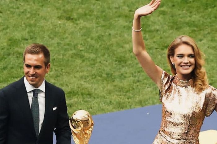 Natalia Vodianova (kanan) membawa trofi Piala Dunia bersama Philipp Lahm