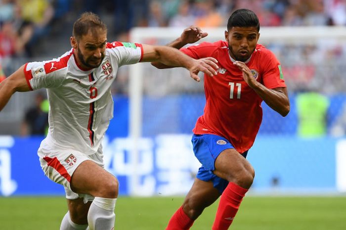 Bek Timnas Serbia, Branislav Ivanovic, berduel dengan penyerang Kosta Rika, Johan Venegas, dalam laga Grup E Piala Dunia 2018 di Samara Arena, Minggu (17/6/2018).