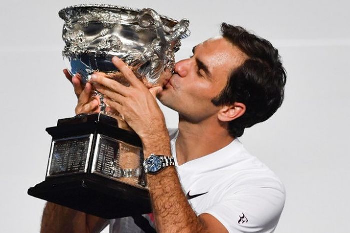 Petenis putra Swiss, Roger Federer, berpose dengan trofi yang didapatnya sebagai juara Australia Terbuka di Melbourne Park, Minggu (28/1/2018).
